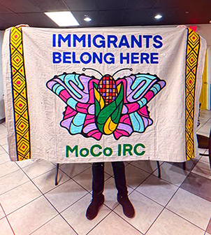 A butterfly quilt with the words "Immigrants Belong Here - MoCo IRC".